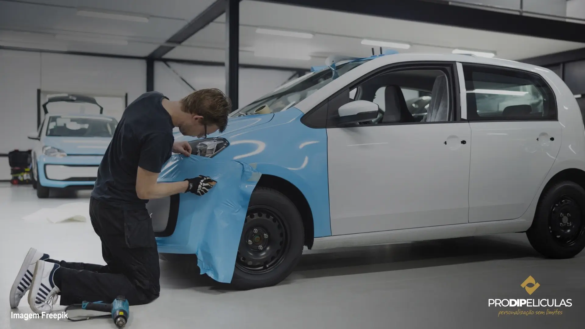 Homem embrulhando frente em um carro com vinil azul